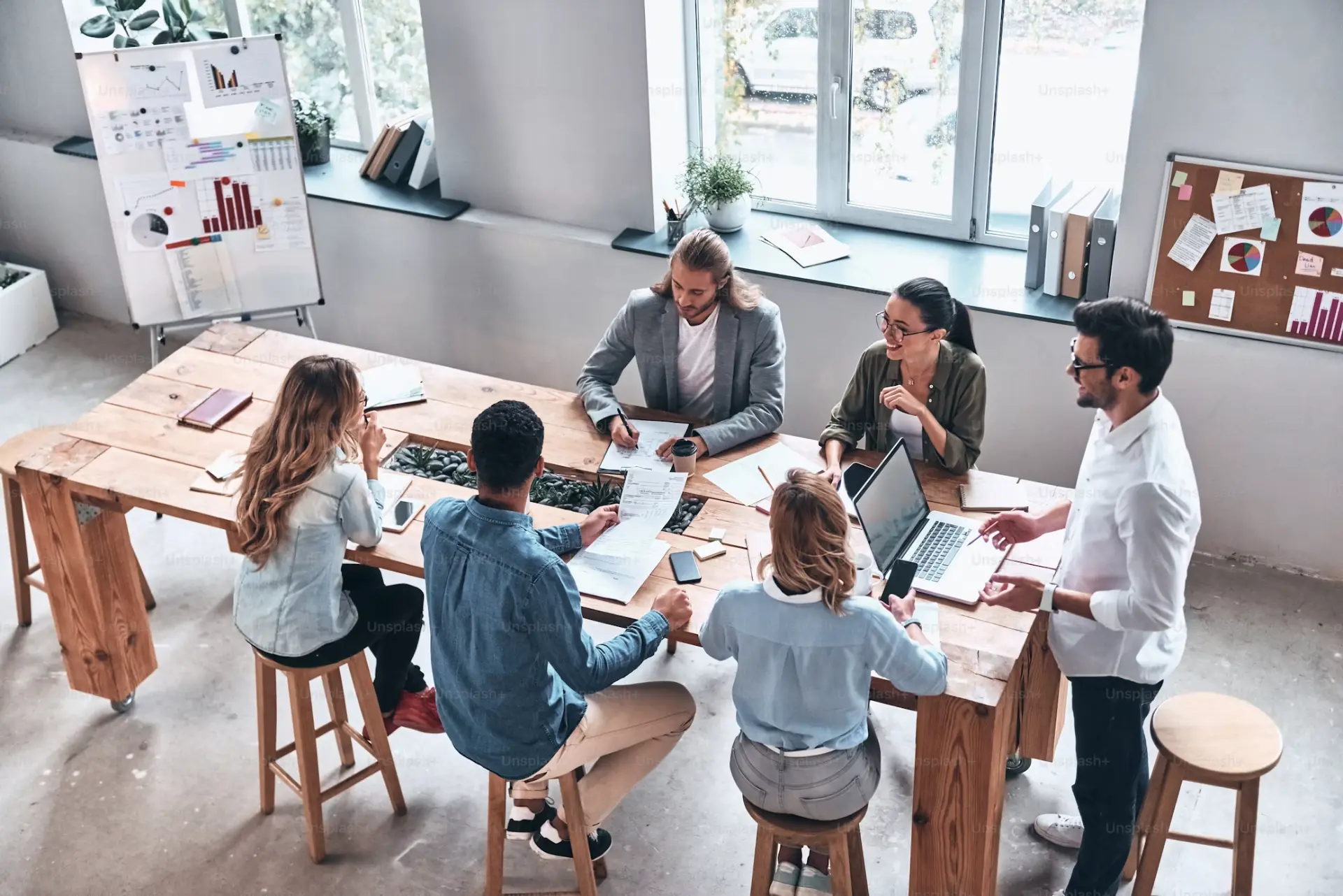 Team of colleagues collaborating around a wooden table in a bright office