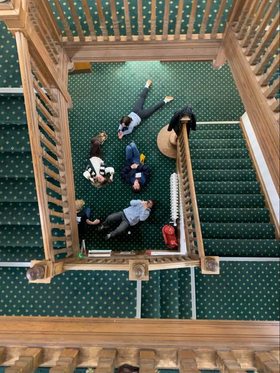 Overhead view of people gathered on a patterned staircase landing